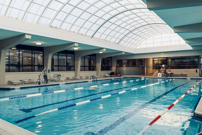 Group fitness class lunging in a bright studio